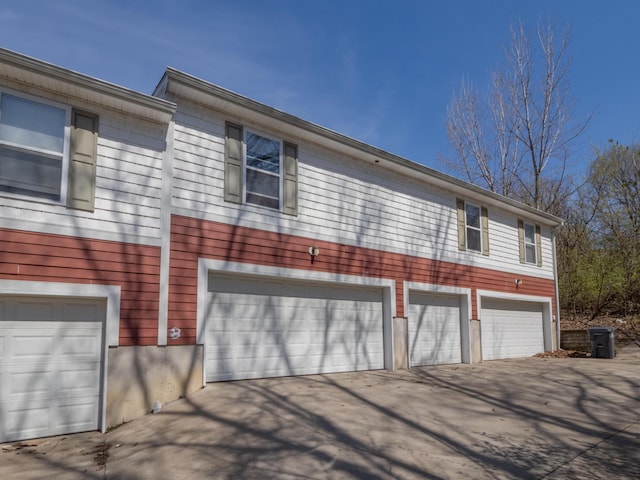 view of side of home with driveway and a garage