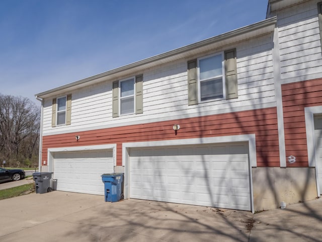 view of side of property with a garage and concrete driveway