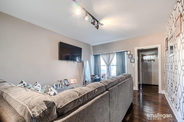 living room featuring track lighting, baseboards, and dark wood-type flooring