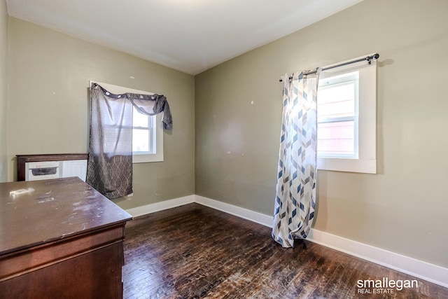 unfurnished office featuring baseboards and dark wood-style floors