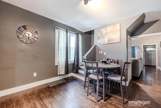 dining area with wood finished floors, visible vents, and baseboards