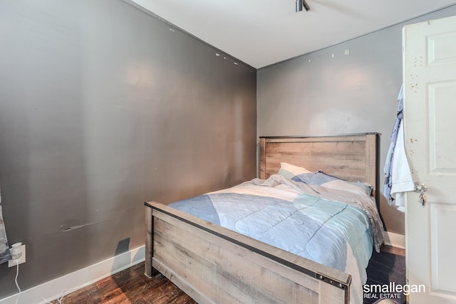 bedroom with wood finished floors and baseboards