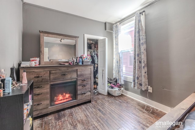interior space featuring hardwood / wood-style floors, baseboards, a glass covered fireplace, and a closet
