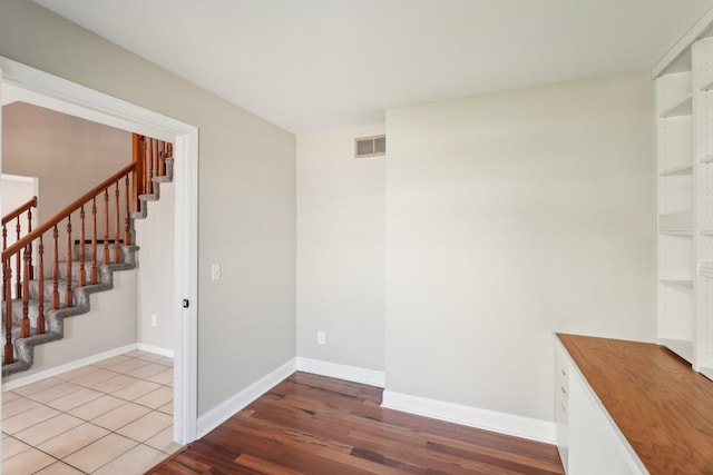 4658 White Pine Ct, Ypsilanti, MI 48197 - spare room with stairway, baseboards, wood finished floors, and visible vents