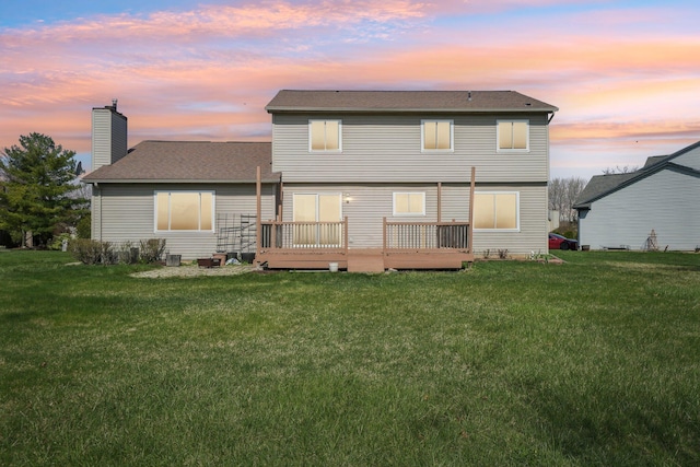 4658 White Pine Ct, Ypsilanti, MI 48197 - back of property at dusk with a lawn, a chimney, a shingled roof, and a deck