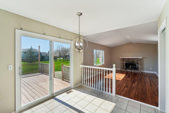 4658 White Pine Ct, Ypsilanti, MI 48197 - unfurnished dining area with tile patterned flooring, a chandelier, lofted ceiling, a brick fireplace, and visible vents