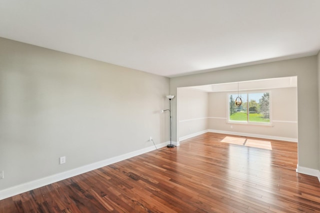 4658 White Pine Ct, Ypsilanti, MI 48197 - empty room with wood finished floors, baseboards, and a notable chandelier