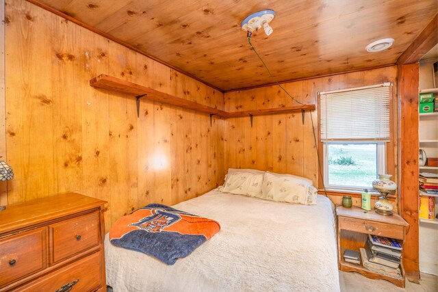 carpeted bedroom featuring wooden ceiling and wood walls