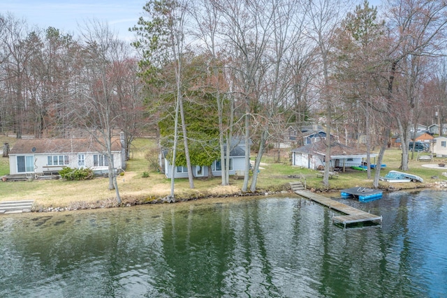 dock area with a lawn and a water view