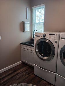 935 Stony Lake Ct, Oxford, MI 48371 - washroom with washing machine and clothes dryer, baseboards, dark wood-type flooring, and cabinet space