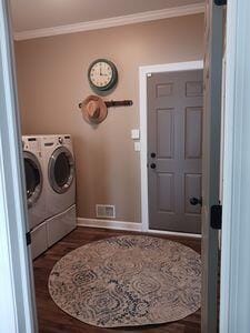 935 Stony Lake Ct, Oxford, MI 48371 - clothes washing area featuring washer and clothes dryer, baseboards, ornamental molding, dark wood-type flooring, and laundry area
