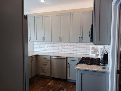 935 Stony Lake Ct, Oxford, MI 48371 - kitchen with stainless steel appliances, gray cabinets, decorative backsplash, and dark wood-style flooring