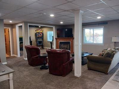 935 Stony Lake Ct, Oxford, MI 48371 - carpeted living area with a paneled ceiling, baseboards, and a fireplace