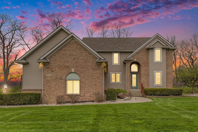 traditional-style home featuring a front lawn and brick siding