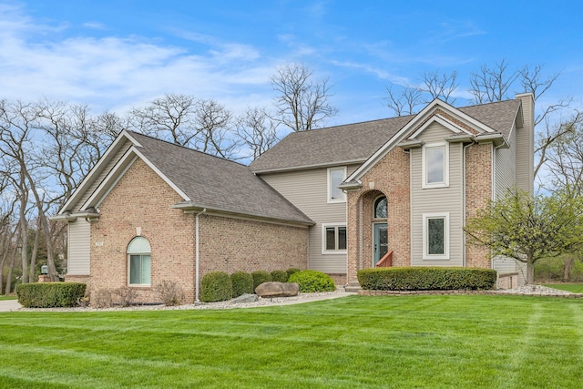 traditional-style house with brick siding, roof with shingles, and a front yard