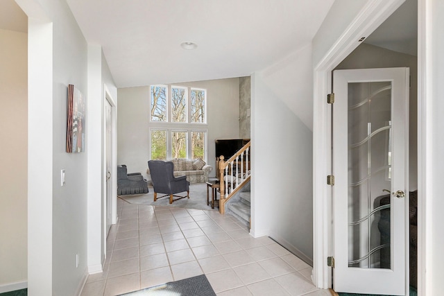 hallway with light tile patterned floors and baseboards