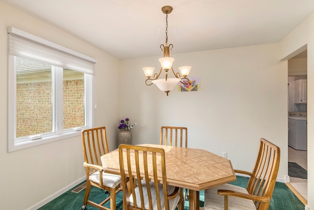 carpeted dining space with baseboards, washer / clothes dryer, and an inviting chandelier