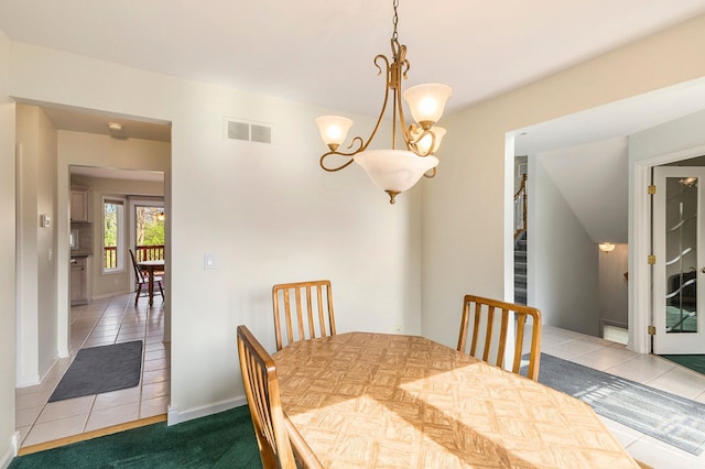 tiled dining space with stairs, a chandelier, baseboards, and visible vents