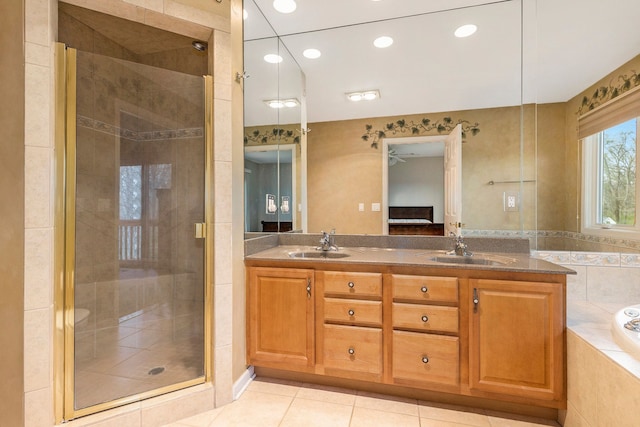 ensuite bathroom featuring a garden tub, a sink, and a shower stall
