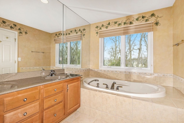 full bath featuring a garden tub, a sink, tile patterned floors, and double vanity