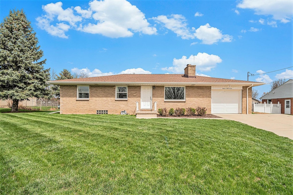 ranch-style house with a chimney, concrete driveway, fence, brick siding, and a garage