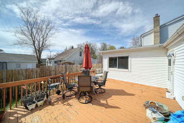 wooden terrace with outdoor dining area and fence
