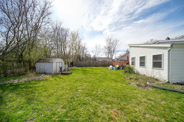 view of yard featuring a fenced backyard, an outdoor structure, and a storage shed