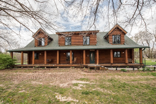 log home with roof with shingles, covered porch, and log exterior