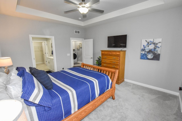4336 Silica Dr, Lake Orion, MI 48359 - carpeted bedroom featuring washer / dryer, ensuite bath, a tray ceiling, visible vents, and baseboards
