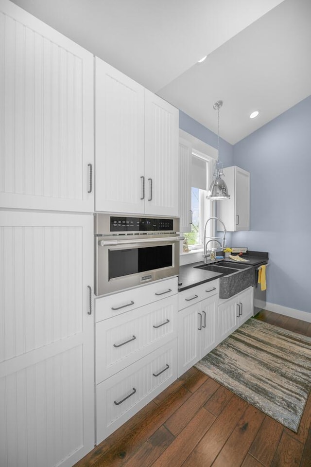 21373 Sail Bay Dr, Cassopolis, MI 49031 - kitchen with stainless steel oven, dark wood finished floors, a sink, decorative light fixtures, and dark countertops