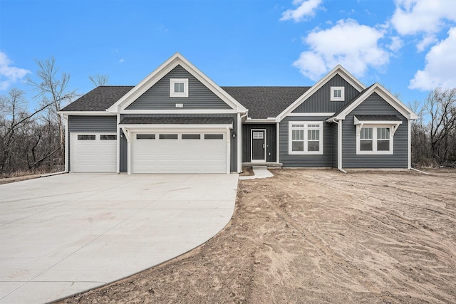 craftsman-style house featuring board and batten siding, an attached garage, a shingled roof, and concrete driveway