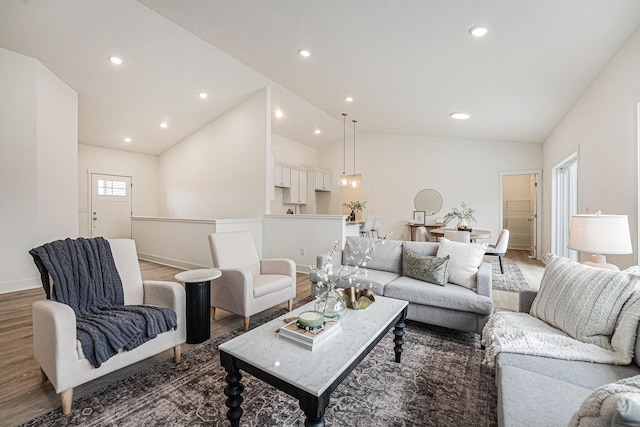 living room featuring baseboards, vaulted ceiling, wood finished floors, and recessed lighting