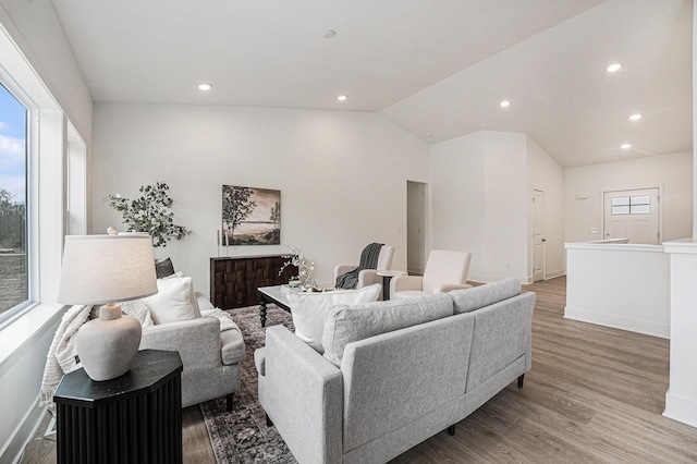 living area with recessed lighting, wood finished floors, lofted ceiling, and baseboards