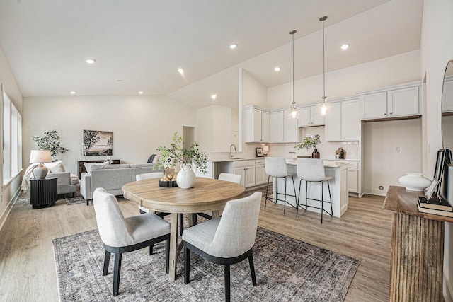 dining area featuring recessed lighting, vaulted ceiling, and light wood finished floors