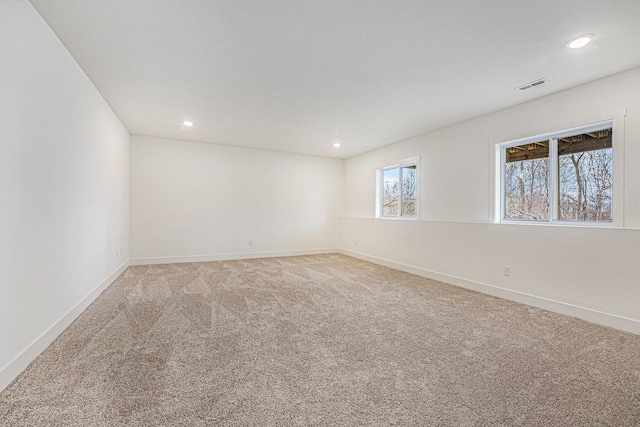 unfurnished room featuring recessed lighting, baseboards, visible vents, and light colored carpet