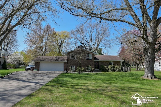 view of front of home with an attached garage, brick siding, aphalt driveway, and a front yard
