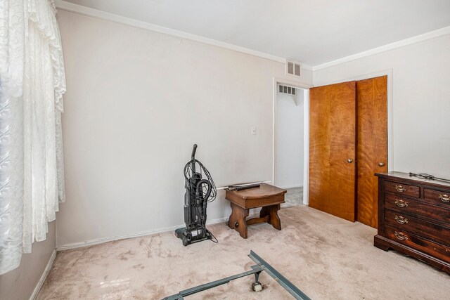 carpeted bedroom with baseboards, visible vents, and crown molding