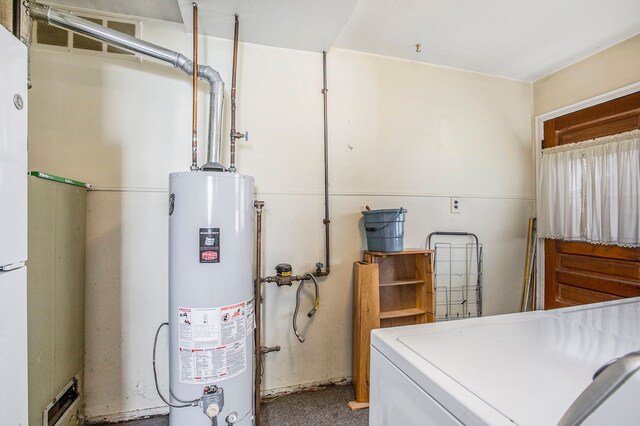 clothes washing area featuring water heater, washer / clothes dryer, and laundry area