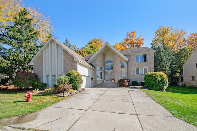 28909 Hidden Trl, Farmington Hills, MI 48331 - view of front facade with concrete driveway, brick siding, a front lawn, and an attached garage
