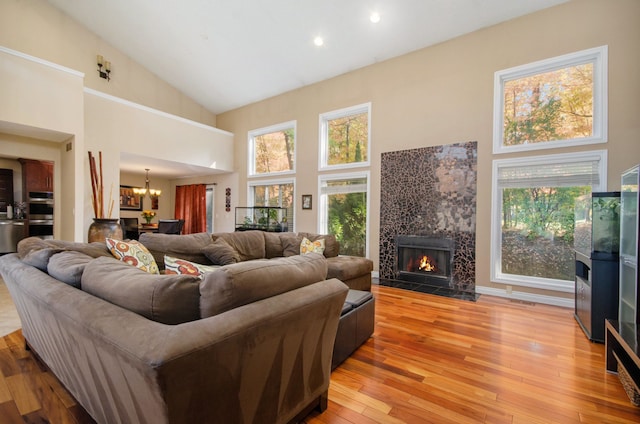 28909 Hidden Trl, Farmington Hills, MI 48331 - living room with a tiled fireplace, high vaulted ceiling, a chandelier, light wood-style flooring, and recessed lighting