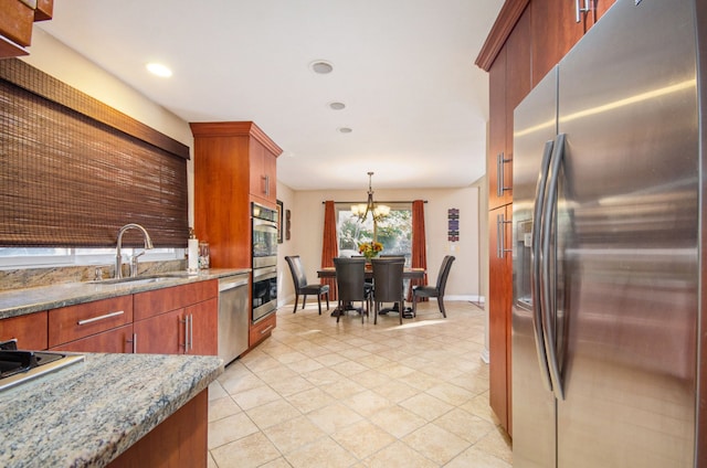 28909 Hidden Trl, Farmington Hills, MI 48331 - kitchen featuring appliances with stainless steel finishes, a sink, baseboards, a chandelier, and brown cabinets