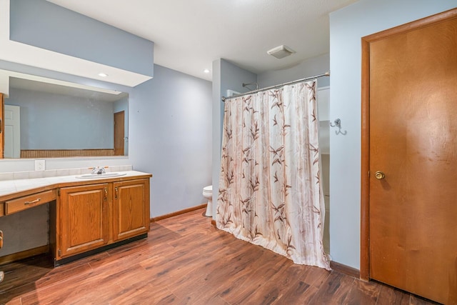 full bath with wood finished floors, vanity, curtained shower, baseboards, and toilet