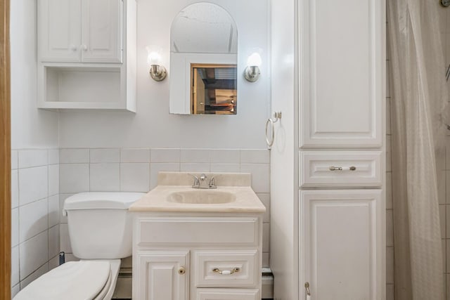 full bathroom featuring tile walls, toilet, vanity, and wainscoting