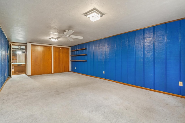 unfurnished bedroom featuring a ceiling fan, carpet flooring, and a textured ceiling