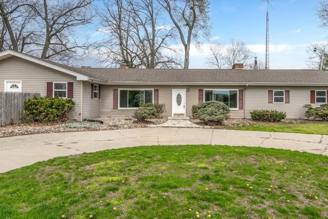 ranch-style house with fence, a front lawn, and a chimney