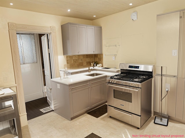 kitchen featuring stainless steel range with gas cooktop, recessed lighting, a sink, and light countertops