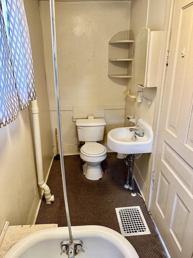 bathroom featuring baseboards and toilet