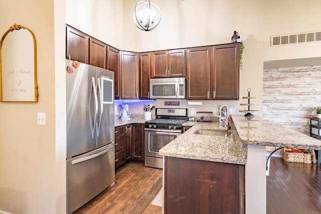 1242 Bay, Holly, MI 48442 - kitchen with a sink, stainless steel appliances, a peninsula, dark wood-type flooring, and visible vents