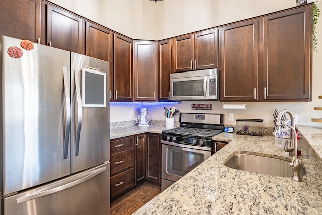 1242 Bay, Holly, MI 48442 - kitchen featuring dark brown cabinetry, dark wood-style flooring, appliances with stainless steel finishes, light stone countertops, and a sink