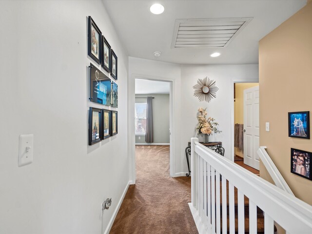hallway with recessed lighting, visible vents, an upstairs landing, carpet floors, and baseboards
